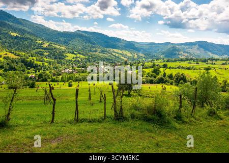champs ruraux sur les collines de l'ukraine en été. paysage de campagne grand angle de transcarpathia avec des clôtures de bâton dans la lumière tamisée. villa uzhok Banque D'Images