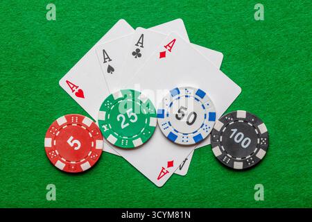Casino, poker et concept de jeu. Quatre as avec des jetons sur la table verte du casino. Banque D'Images
