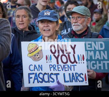 Une femme tient une pancarte alors qu'elle marche dans une manifestation No Kings à Eugene, Oregon, le 18 octobre 2025. Banque D'Images