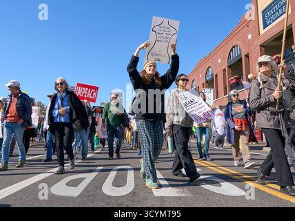 Une femme tient une pancarte alors qu'elle marche dans une manifestation No Kings à Eugene, Oregon, le 18 octobre 2025. Banque D'Images