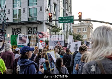 Asheville, États-Unis. 18 octobre 2025. Les manifestants défilent avec des pancartes lors du deuxième rassemblement « No Kings » - l'événement d'une journée est la plus grande action civile depuis cinquante-cinq ans aux États-Unis. Crédit : Gloria Good/AlamyLive News Banque D'Images