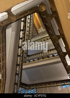Regardant un escalier en colimaçon avec des garde-corps en métal ornées dans un intérieur de bâtiment historique. Photo mobile Banque D'Images