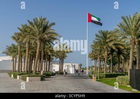Drapeau des Émirats arabes Unis à Abu Dhabi, Émirats arabes Unis, avec des touristes. Banque D'Images