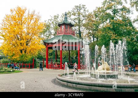 Berlin, Allemagne - 8 octobre 2025 : Zoo de Berlin (Zoologischer Garten Berlin) en automne. Visiteurs se promenant près de l'emblématique fontaine du Lion (Loewenbrunnen). Pagode de style chinois et pavillon de panda sur bkgd Banque D'Images