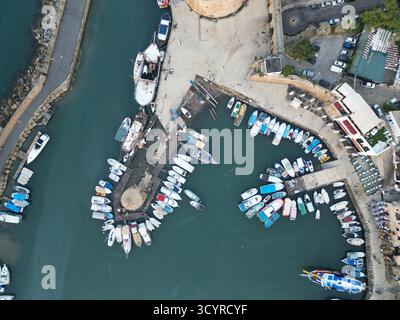Bateaux colorés ancrés dans un port animé pendant l'après-midi dans une ville côtière Banque D'Images