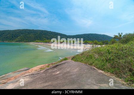 Plage de Guaiuba, Guaruja SP, Brésil. Journée ensoleillée sur la petite baie avec mer tranquille. Image des loisirs et du tourisme sur la côte de Sao Paulo. Collines couvertes Banque D'Images