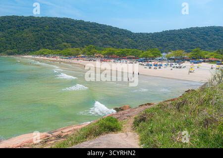 Plage de Guaiuba, Guaruja SP, Brésil. Journée ensoleillée sur la petite baie avec mer tranquille. Image des loisirs et du tourisme sur la côte de Sao Paulo. Collines couvertes Banque D'Images