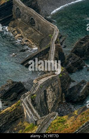 Zigzag Stone Stairs Bridge reliant le continent à Gaztelugatxe Islet, Vizcaya, Espagne. Architecture médiévale sur la Côte Basque dans le golfe de Gascogne Banque D'Images