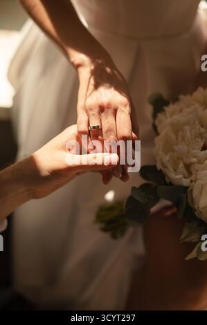 Gros plan d'une mariée et d'un marié tenant la main, avec un bouquet. Banque D'Images