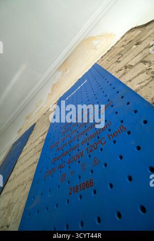 18.06.2025, Allemagne, Brême, Brême - tapis chauffants sur le mur intérieur d'un ancien bâtiment pour sécher après des dégâts d'eau causés par un voisin. 00A250 Banque D'Images