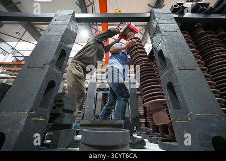 SUQIAN, CHINE - 20 OCTOBRE 2025 - des travailleurs produisent des isolants en porcelaine à l'usine de porcelaine électrique de Suzhou (Suqian) Co., Ltd dans le parc industriel de Susu dans la ville de Suqian, province du Jiangsu, Chine, le 20 octobre 2025. Banque D'Images