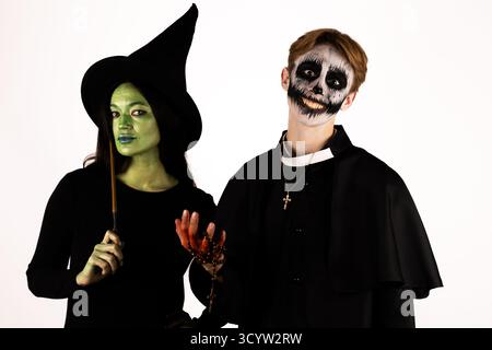 Les mannequins posent à Halloween, avec un habillé en sorcière et squelette-visage Banque D'Images