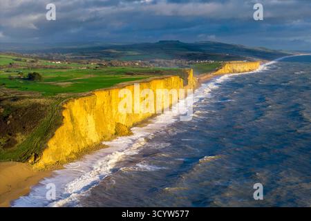 West Bay, Dorset, Royaume-Uni. 20 octobre 2025. Météo britannique. De grandes vagues de la mer agitée s'écrasent à terre sur la plage sous les falaises de West Bay dans le Dorset par un après-midi de fortes averses de pluie et de rafales de vent. Crédit photo : Graham Hunt/Alamy Live News Banque D'Images