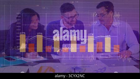 Équipe collaboratrice examinant les graphiques avec des stylos dans la salle de conférence, avec des documents et des graphiques numériques Banque D'Images