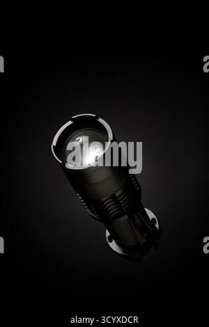 Image studio de haute qualité d'une lampe de poche de qualité professionnelle debout sur une surface noire. L'image utilise un éclairage ciblé pour souligner son fro Banque D'Images