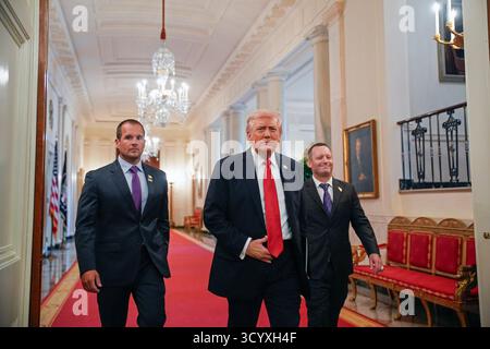 Washington DC, États-Unis. 20 octobre 2025. Le président AMÉRICAIN Donald Trump, au centre, flanqué de Brad Neffendorf, entraîneur-chef des pilotes LSU Shreveport, à gauche, et de Jay Johnson, entraîneur-chef des Tigres LSU, à droite, arrive pour participer à une visite avec les champions de baseball LSU et LSU Shreveport dans la salle est de la Maison Blanche à Washington, DC, États-Unis, le 20 octobre 2025. Photo de Yuri Gripas/ABACAPRESS.COM crédit : UPI/Alamy Live News Banque D'Images