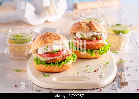 Hamburger de poisson frais fait dans la cuisine d'été. Hamburger de poisson avec légumes et poisson. Banque D'Images