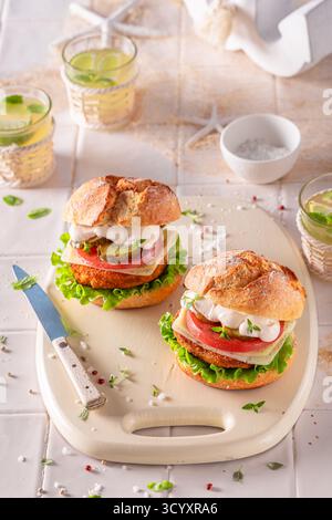 Hamburger de poisson sain fabriqué dans la cuisine d'été. Hamburger maison avec pain et légumes. Banque D'Images