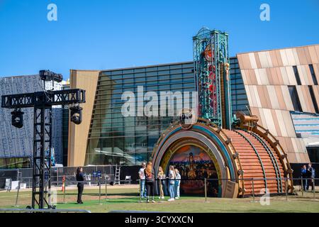 Les visiteurs se rassemblent autour de l'exposition promotionnelle Universal Epic Universe à l'extérieur de Coca-Cola World, avec une structure de portail de temps à thème Banque D'Images