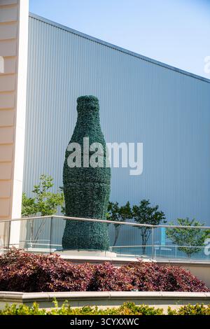 Un topiaire en forme de bouteille emblématique de Coca-Cola se dresse à l'extérieur du bâtiment World of Coca-Cola sur Baker Street sous un ciel bleu clair Banque D'Images