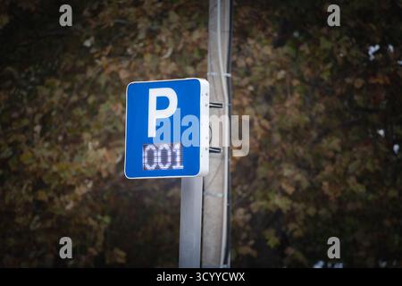 Un panneau bleu de stationnement routier avec un P blanc et un panneau numérique indiquant 001 indique qu'il ne reste qu'une place de stationnement. L'affichage moderne illustre le temps réel Banque D'Images