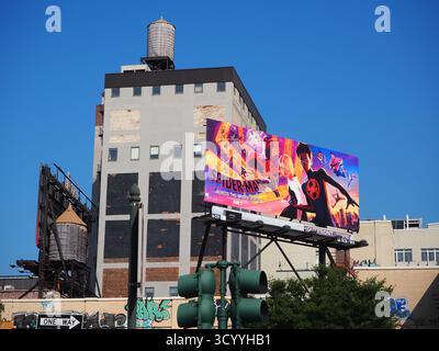 Spider-Man à travers le panneau d'affichage Spider-verse lors d'une journée ensoleillée à New York City avec ciel bleu et château d'eau Banque D'Images