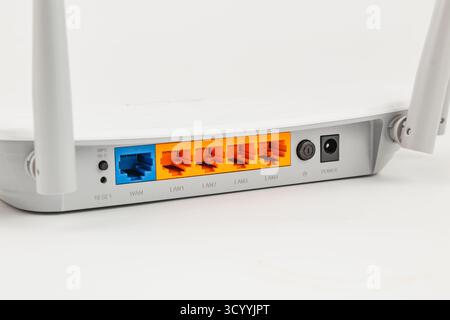 L'arrière d'un routeur sans fil montre différents ports Ethernet et une connexion d'alimentation. L'appareil est conçu pour la mise en réseau domestique et l'accès à Internet. Banque D'Images