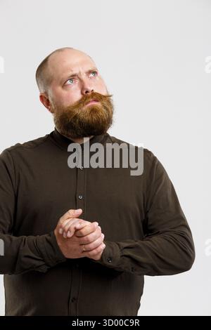 Santa Claus dans brown chemise avec barbe et moustache au gingembre sur fond gris vide Banque D'Images