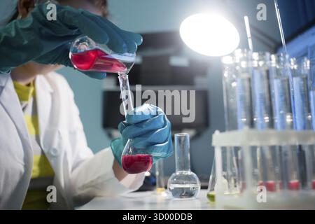 Laboratorian avec flacons et tubes sur trépied à 24 Banque D'Images