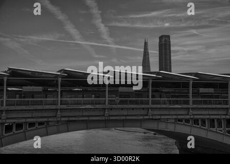 Vue en noir et blanc du pont ferroviaire de Blackfriars et de la gare avec le Shard et un gratte-ciel de Blackfriars en arrière-plan, Londres, Royaume-Uni. Banque D'Images