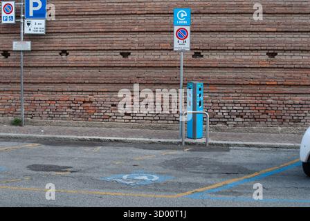 Cremona, Italie -2 octobre 2025 borne de recharge bleue pour véhicule électrique debout dans une place de stationnement désignée avec des symboles d'accessibilité et un panneau de signalisation Banque D'Images