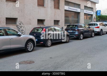 Cremona, Italie -2 octobre 2025 véhicules garés le long d'une rue étroite de la ville européenne, présentant le stationnement urbain quotidien, les voitures compactes, l'architecture et Banque D'Images