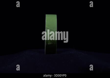 rouleau vert unique de ruban de masquage décorateurs isolé sur un fond noir Banque D'Images