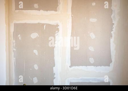 Vue de face des panneaux de gypse bruns installés sur la cloison de séparation du bâtiment en construction sur le chantier de construction. Banque D'Images