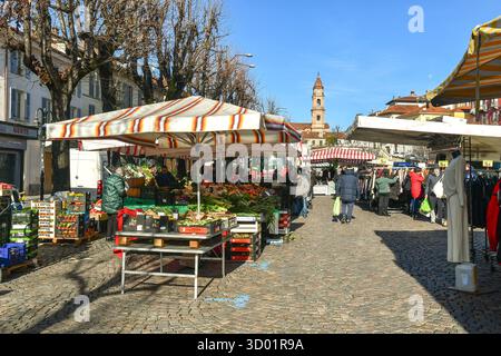 Stands vendant différents types de marchandises (vêtements, fruits et légumes), au marché hebdomadaire dans la vieille ville, Bra (Cuneo), Piémont, Italie Banque D'Images