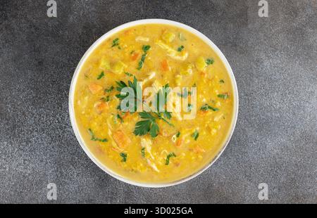 Soupe traditionnelle indienne Mulligatawny avec lentilles et poulet sur fond sombre. Vue de dessus. Banque D'Images