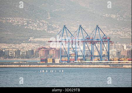 Grandes grues bleues au port de Malaga avec l'horizon de la ville et les montagnes en arrière-plan sur une journée d'été claire Banque D'Images