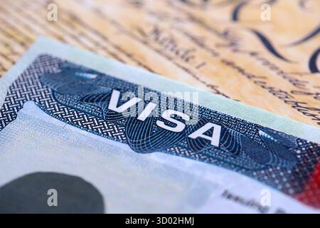Vue rapprochée d'un visa américain estampillé sur une page de passeport avec fond de Constitution américaine. Concept de voyage et d'immigration Banque D'Images