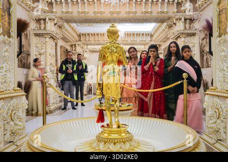 Londres, Royaume-Uni. 20 octobre 2025. Les adorateurs prient et réfléchissent dans une salle élaborée au sein du Mandir. Les gens posent et prennent des clichés avec le bel extérieur. La fête joyeuse et colorée de Diwali, la fête hindoue des lumières, est célébrée au Shri Swaminarayan Mandir, populairement connu sous le nom de Temple Neasden, avec un festival de cérémonies et de bénédictions, de cultes, d'activités familiales, de nourriture, d'étals et un vif feu d'artifice. Crédit : Imageplotter/Alamy Live News Banque D'Images