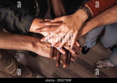 Une vue de dessus en gros plan d'un groupe multiethnique de jeunes amis empilant leurs mains les uns sur les autres dans un puissant symbole de travail d'équipe, la communauté sup Banque D'Images