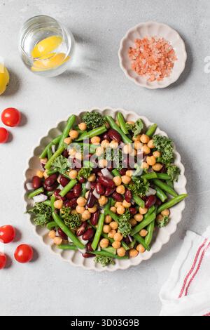 Salade végétalienne saine avec trois types de haricots. Salade saine avec haricots verts, haricots rouges et pois chiches. Concept d'alimentation saine, menu végétarien riche en protéines végétales. Banque D'Images