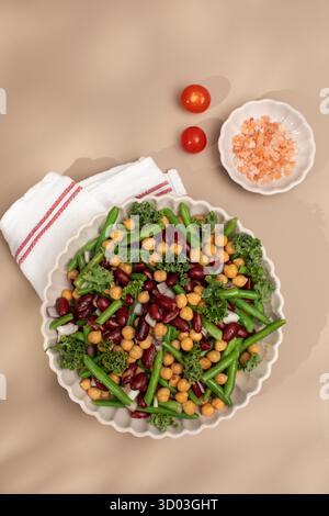 Salade végétalienne saine avec trois types de haricots. Salade saine avec haricots verts, haricots rouges et pois chiches. Concept d'alimentation saine, menu végétarien riche en protéines végétales. Banque D'Images