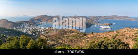 Vue panoramique de l'île de Patmos, montrant le port de Skala, le bateau de croisière et le paysage Hilly Dodécanèse, Grèce Banque D'Images