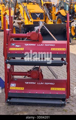 Winsen, Allemagne ; 30 septembre 2025 : deux tondeuses à fléaux rouges empilées FPM LUM 110PRO pour tracteurs compacts au chantier naval d'importateurs de machines agricoles, Showin Banque D'Images