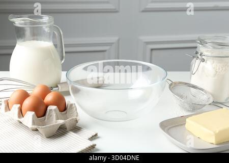 Ingrédients et ustensiles pour faire de la pâte (pâte liquide) sur table blanche à l'intérieur Banque D'Images