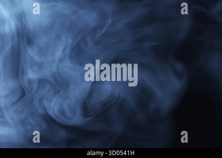 Fumée bleue ou brume tourbillonnant sur fond sombre en mouvement abstrait Banque D'Images
