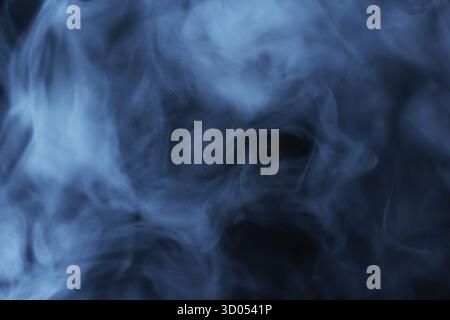 Fumée bleue ou brume tourbillonnant sur fond sombre en mouvement abstrait Banque D'Images