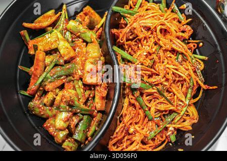Assortiment de banchan coréens épicés (kimchi de concombre et de carotte) dans un bol. Les accompagnements essentiels de K-Food, une cuisine vibrante et authentique. Banque D'Images