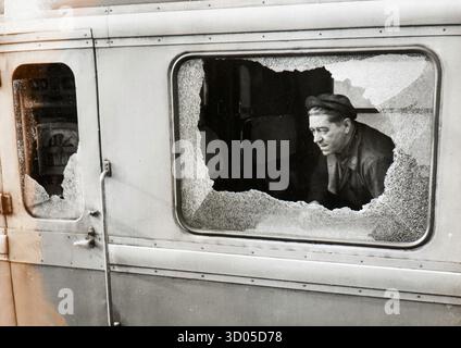 Un homme regarde à travers une fenêtre de train brisée du train 'le Bourbonnais' dans la gare de Paris Gare de Lyon, France après qu'un fusil de chasse est arrivé à Moulin en 1963 (France). Banque D'Images