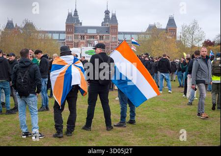 Amsterdam, pays-Bas,Museumplein - 12 octobre 2025 : manifestation anti-immigration, bannière Defend Netherlands, drapeaux néerlandais et Prinsenvlag. Banque D'Images